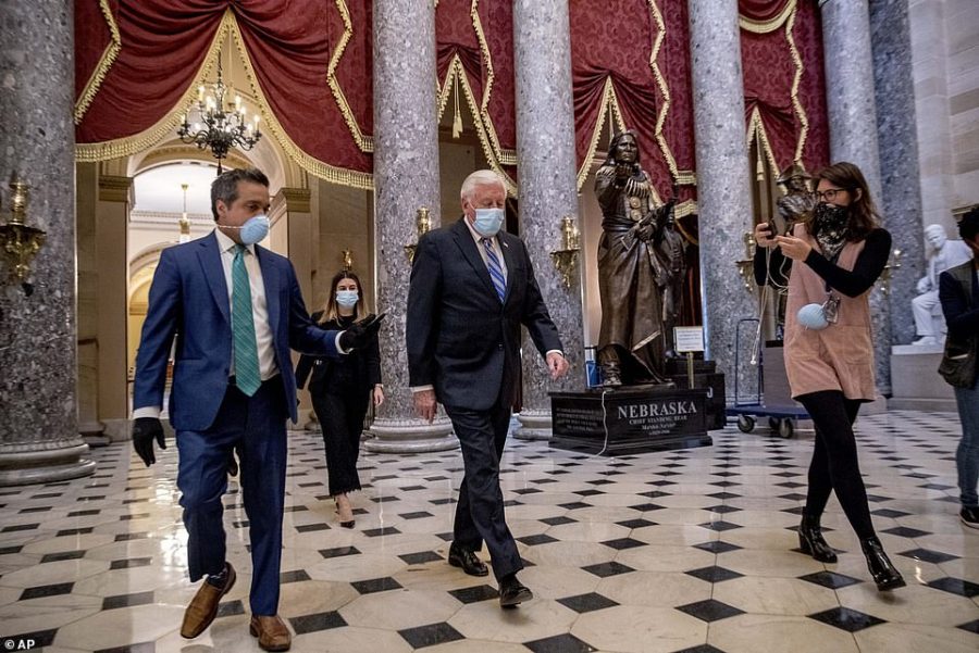 House Majority Leader Steny Hoyer wears a facemask as he traverses the National Statuary Hall
